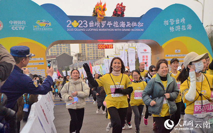 Atlet dan penggemar sukan maraton berlari dalam maraton dilatari bunga sesawi pada 25 Februari. (Foto/ Liu Yi)