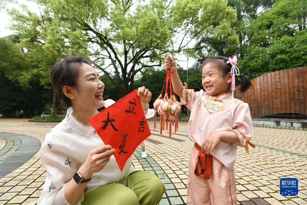 Memasukkan telur rebus ke dalam jaring yang berwarna-warni dan memakaikannya pada leher kanak-kanak pada Hari Lixia juga adalah untuk mendoakan kesihatan. Gambar ini menunjukkan seorang budak perempuan menunjukkan telur rebus yang siap dimasukkan ke dalam jaring di Jiande, Zhejiang pada 5 Mei. (Xinhua/Ning Wenwu)