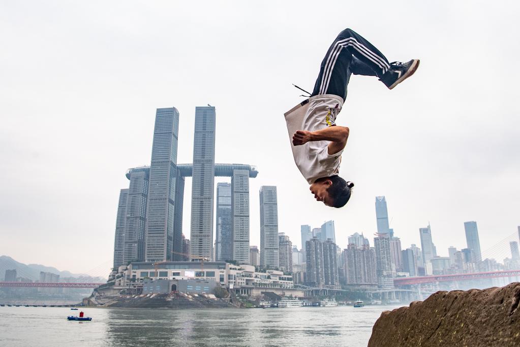 Wen Shunyao menunjukkan aksi parkur di sekitar dermaga Chaotianmen di bandar Chongqing, barat daya China pada 21 April 2023. (Xinhua/Tang Yi)