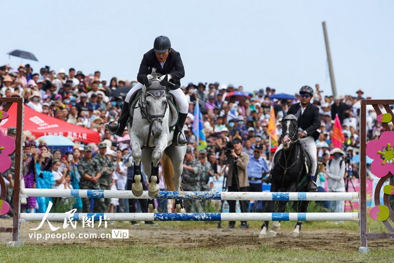 Pada 8 Julai, penunggang menunjukkan kecekapan berkuda dalam acara ekuestrian pada majlis perasmian Festival Sukan Rakyat Barkol 2023. (foto: Li Hua/People.cn)