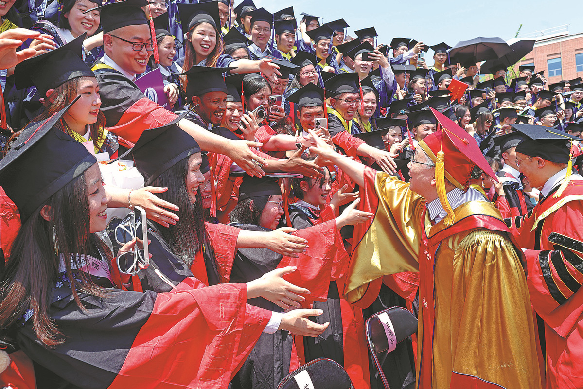 Hou Jianguo (kedua dari kanan), presiden Akademi Sains China, berjabat tangan dengan graduan semasa konvokesyen di Universiti Akademi Sains China di Beijing pada 1 Julai. ZHU XINGXIN/CHINA DAILY