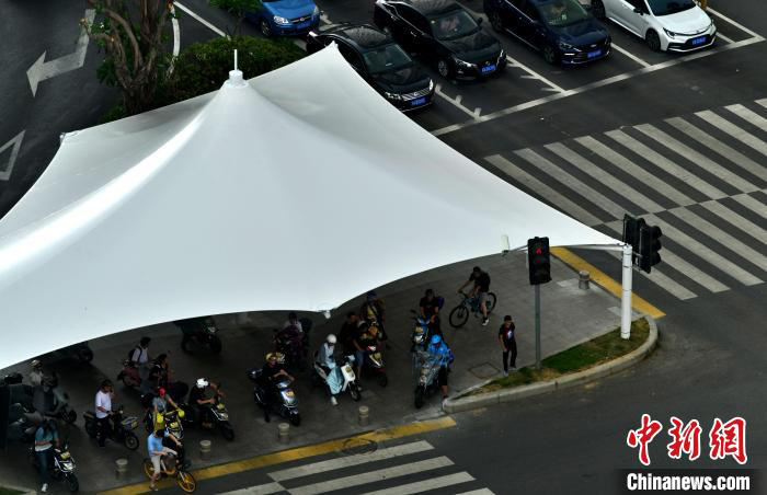 Foto ini menunjukkan empat khemah gergasi yang dibina di persimpangan Jalan Wusi dan Jalan Hualin di bandar Fuzhou untuk melindungi penduduk yang menunggu lampu isyarat daripada hujan dan matahari. (foto: Zhang Bin/Chinanews.cn)