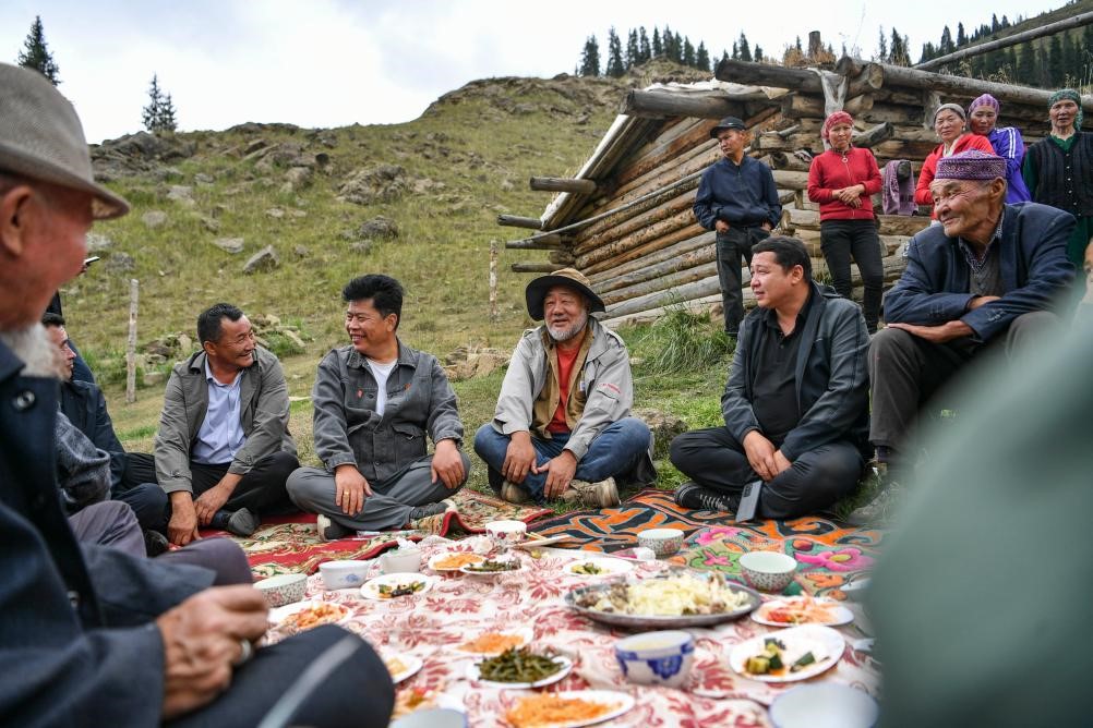 Mentor Pasukan Fotografi Penggembala Wumot, Tan Chengjun menjamu selera bersama penggembala tempatan pada 12 Ogos. (Xinhua/Hu Huhu)