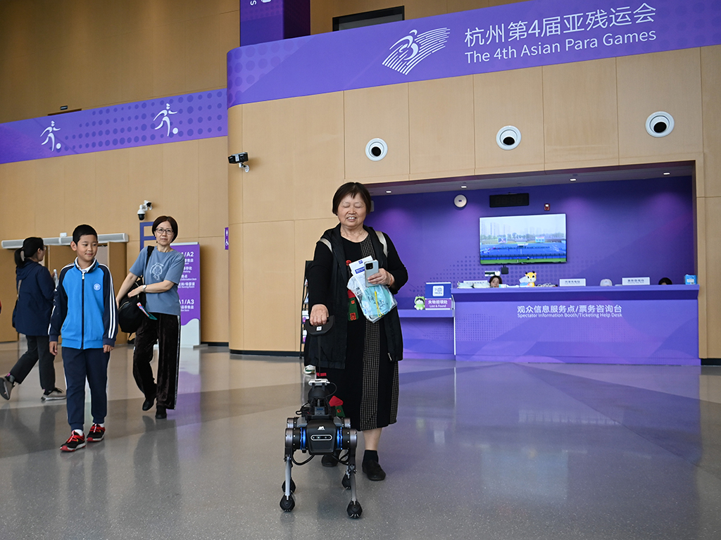 Pada 26 Oktober, penonton mencuba anjing pemandu orang buta elektronik "Xiaoxi" di dewan Stadium Taman Sukan Terusan Gongshu di Hangzhou. (Xinhua/Huang Zongzhi)