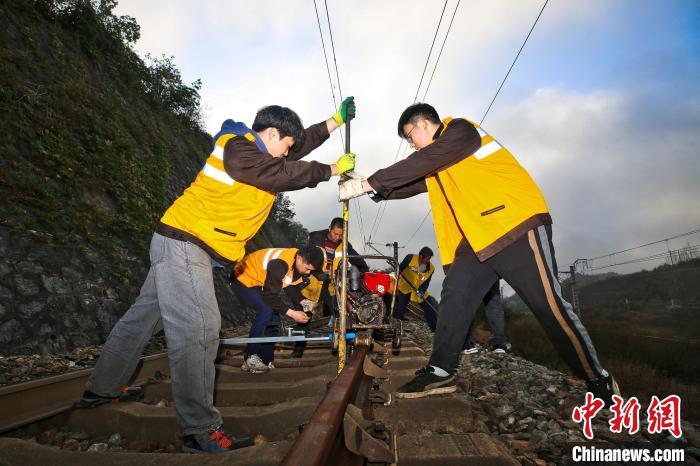 Pekerja penyelenggaraan kereta api memeriksa dan melaraskan rel baharu yang sedang dipasang. (China News Network/Zhang Zhonghai)