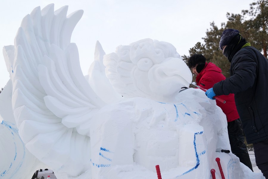 Pengukir membuat arca salji semasa pertandingan salji di Harbin, provinsi Heilongjiang, timur laut China, 12 Disember 2023. (Xinhua/Wang Jianwei)