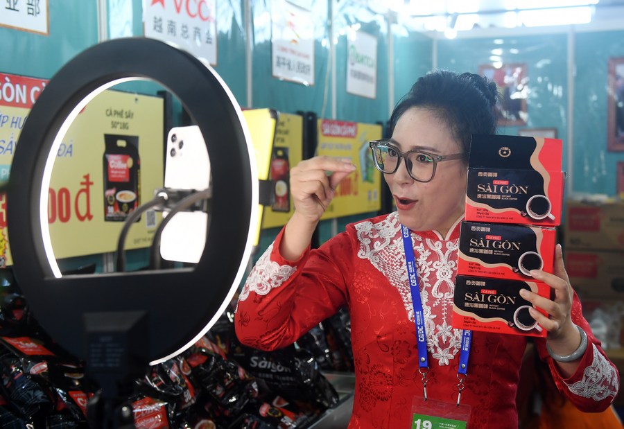 Seorang kakitangan mempromosikan produk kopi Vietnam melalui penstriman langsung semasa Ekspo China-ASEAN ke-19 di Pusat Konvensyen dan Pameran Antarabangsa Nanning, Wilayah Autonomi Zhuang Guangxi, selatan China, 19 September 2022. (Xinhua/Lu Boan)