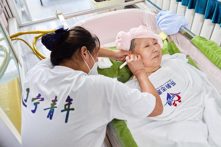 Seorang pembantu melayan seorang warga tua di rumahnya di Shenyang, provinsi Liaoning, timur laut China, 17 Jun 2023. (Xinhua)