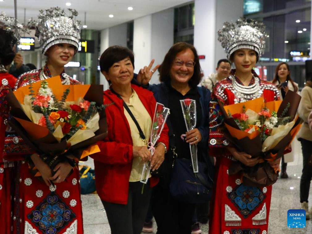 Pelancong dari Malaysia bergambar dengan penghibur di Lapangan Terbang Antarabangsa Longdongbao di Guiyang, ibu provinsi Guizhou di barat daya China, 12 Mac 2024. (Foto/Xinhua)