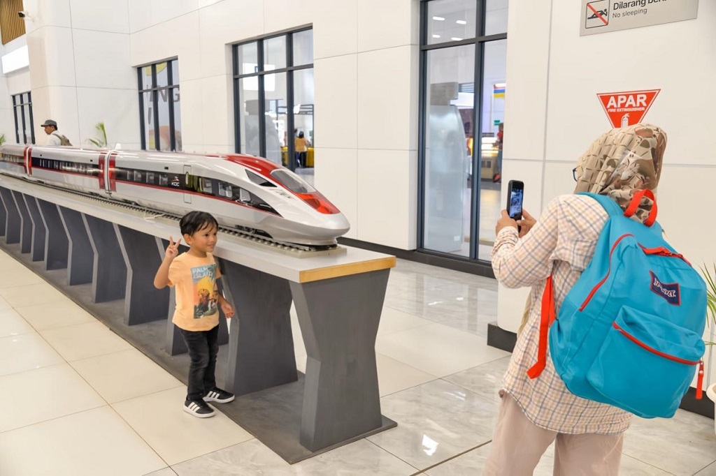 Pada 3 Mac 2024, seorang kanak-kanak mengambil gambar dengan model EMU Kereta Api Berkelajuan Tinggi Jakarta-Bandung di stesen Jakarta.