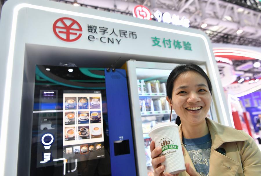 Seorang pengunjung menunjukkan secawan kopi yang dibeli menggunakan yuan digital China, atau e-CNY, pada Sidang Kemuncak China Digital ke-6 di provinsi Fujian, tenggara China, 26 April 2023. (Xinhua/Wei Peiquan)