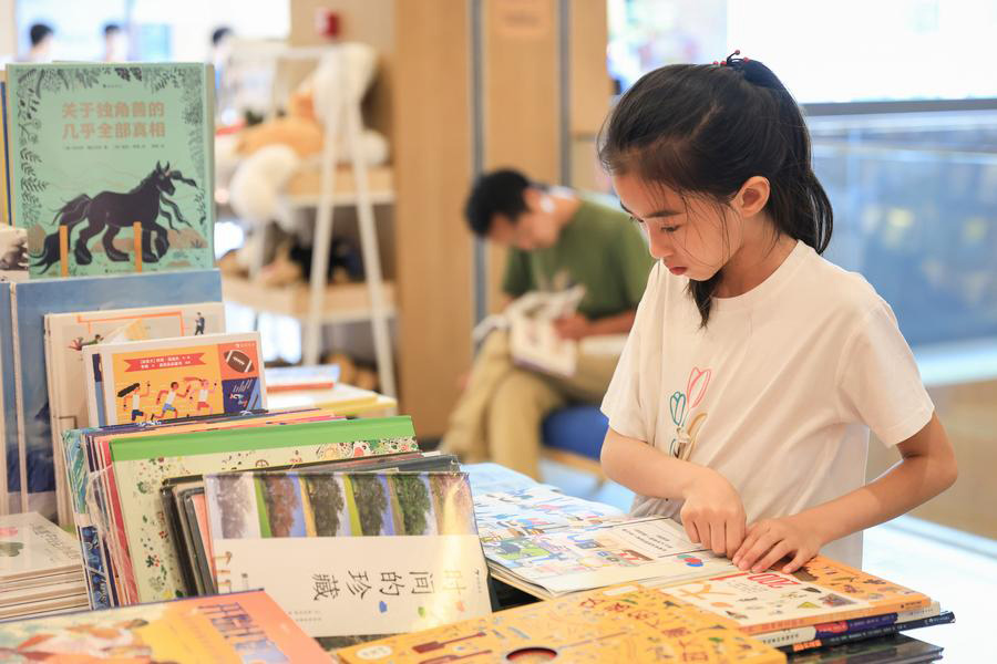 Seorang kanak-kanak membaca buku di kedai buku di Nanjing, Wilayah Jiangsu, timur China, 8 Julai 2023. Pelajar di seluruh negara menikmati pelbagai aktiviti semasa cuti musim panas. (Xinhua/Su Yang)