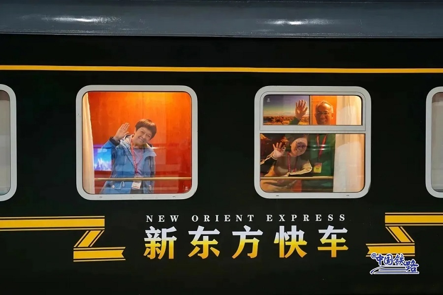 Pelancong melambai dari kereta api khas pelancong New Orient Express. (Foto pusat media Syarikat Kumpulan Biro Kereta Api Urumqi China)