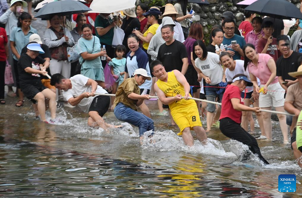 Penduduk kampung mengambil bahagian dalam pertandingan tarik tali di Perbandaran Wangdong di Kaunti Autonomi Rongshui Miao di Wilayah Autonomi Guangxi Zhuang, selatan China, 18 Ogos 2024. Sejak beberapa tahun mutakhir, Perbandaran Wangdong telah memanfaatkan sumber airnya yang banyak untuk menggalakkan daya hidup luar bandar. Disokong oleh "bantuan berpasangan" dari Bandar Lianjiang di Provinsi Guangdong, perbandaran itu berjaya menganjurkan pertandingan sukan air, nyanyian duet lagu gunung dan aktiviti bertemakan warisan budaya tidak ketara di sekolah. Inisiatif ini bertujuan untuk membina jenama "budaya air" dan memajukan pembangunan pelancongan budaya etnik. (Xinhua/Huang Xiaobang)