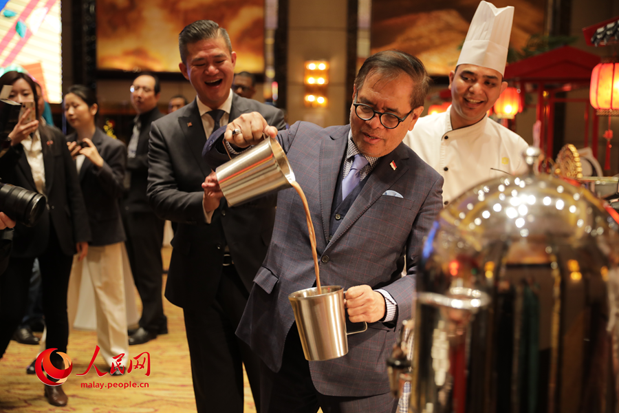 Duta Besar Indonesia ke China, Djauhari Oratmangun sedang mencuba membuat teh tarik, minuman pengenalan Malaysia semasa program Festival Gastronomi Malaysia di Beijing, ibu negara China, pada Selasa. (Wang Jing/People’s Daily Online)