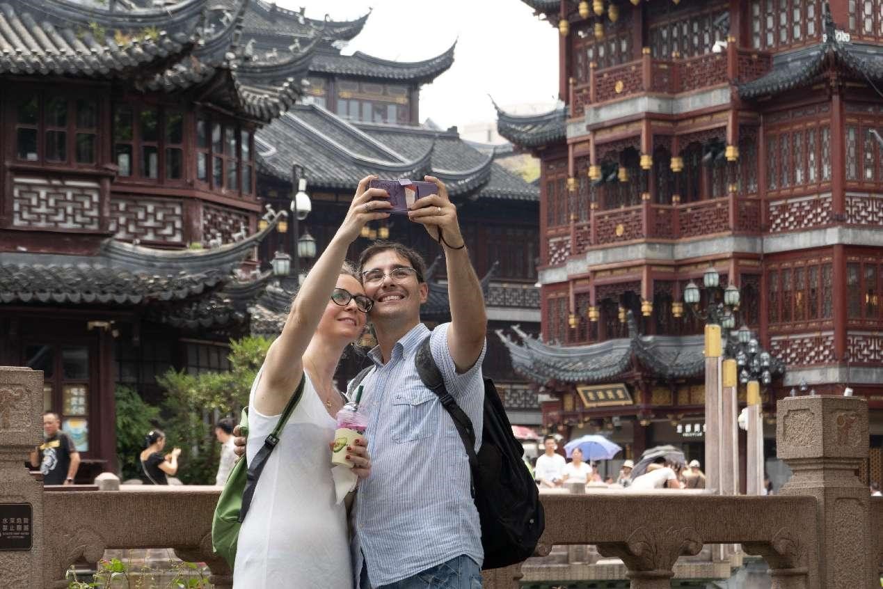 Pelancong asing sedang bergambar di Yuyuan Garden Mall di Shanghai, pada 2 Ogos 2024. (People’s Daily Online/Wang Gong)