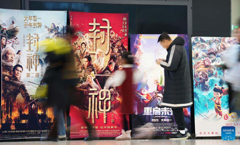 Foto orang ramai melintasi poster filem di sebuah pawagam di Shenyang, Provinsi Liaoning, pada 4 Februari 2025. (Xinhua/Li Gang)