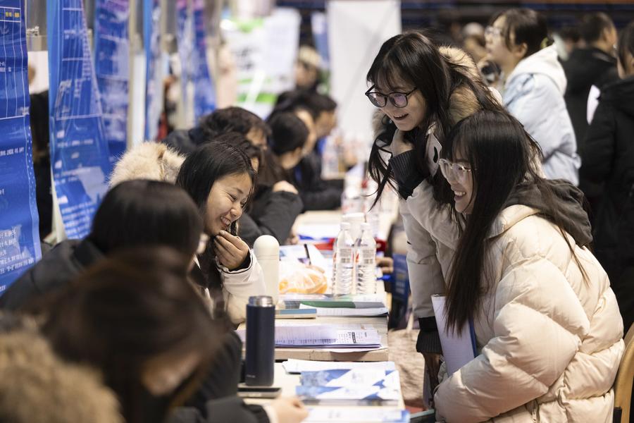 Bakal graduan kerja sedang berkomunikasi dengan pihak majikan di pesta kerjaya untuk graduan tahun 2025 di Universiti Heilongjiang di Harbin, timur laut China pada 23 Disember 2024. (Xinhua/Zhang Tao)