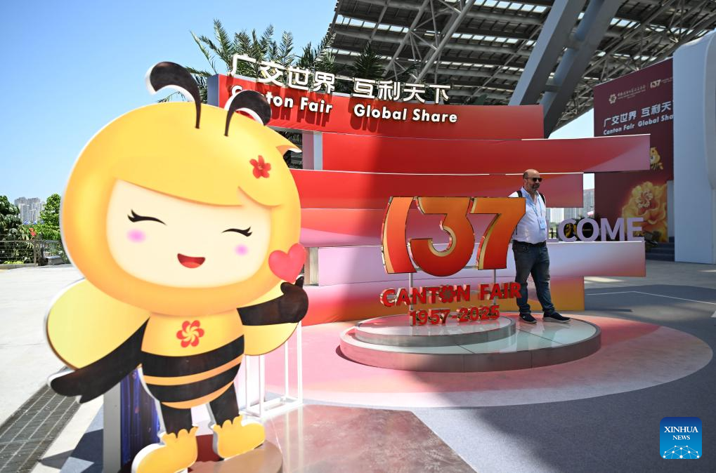 Seorang lelaki sedang bergaya untuk berfoto di hadapan venue ‘Canton Fair’. (Xinhua/Deng Hua)