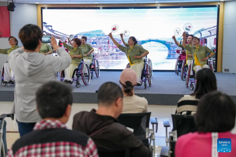 Song Aixia (dua dari kanan, barisan pertama di pentas) dan rakan-rakannya membuat persembahan tarian berkerusi roda di pusat khidmat komuniti di Nanjing, Provinsi Jiangsu di timur China pada 27 April 2025. (Xinhua/Li Bo)