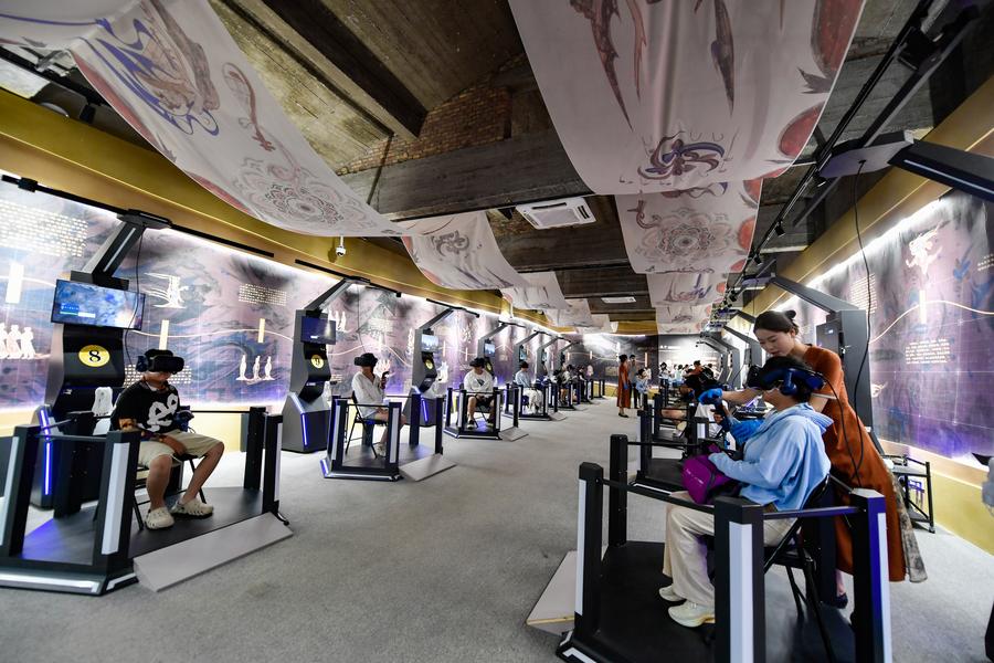 Pelawat menggunakan peralatan realiti maya (VR) untuk mengunjungi Groto Mogao di Dunhuang, provinsi Gansu, barat laut China, 22 Julai 2024. (Xinhua/Lang Bingbing)