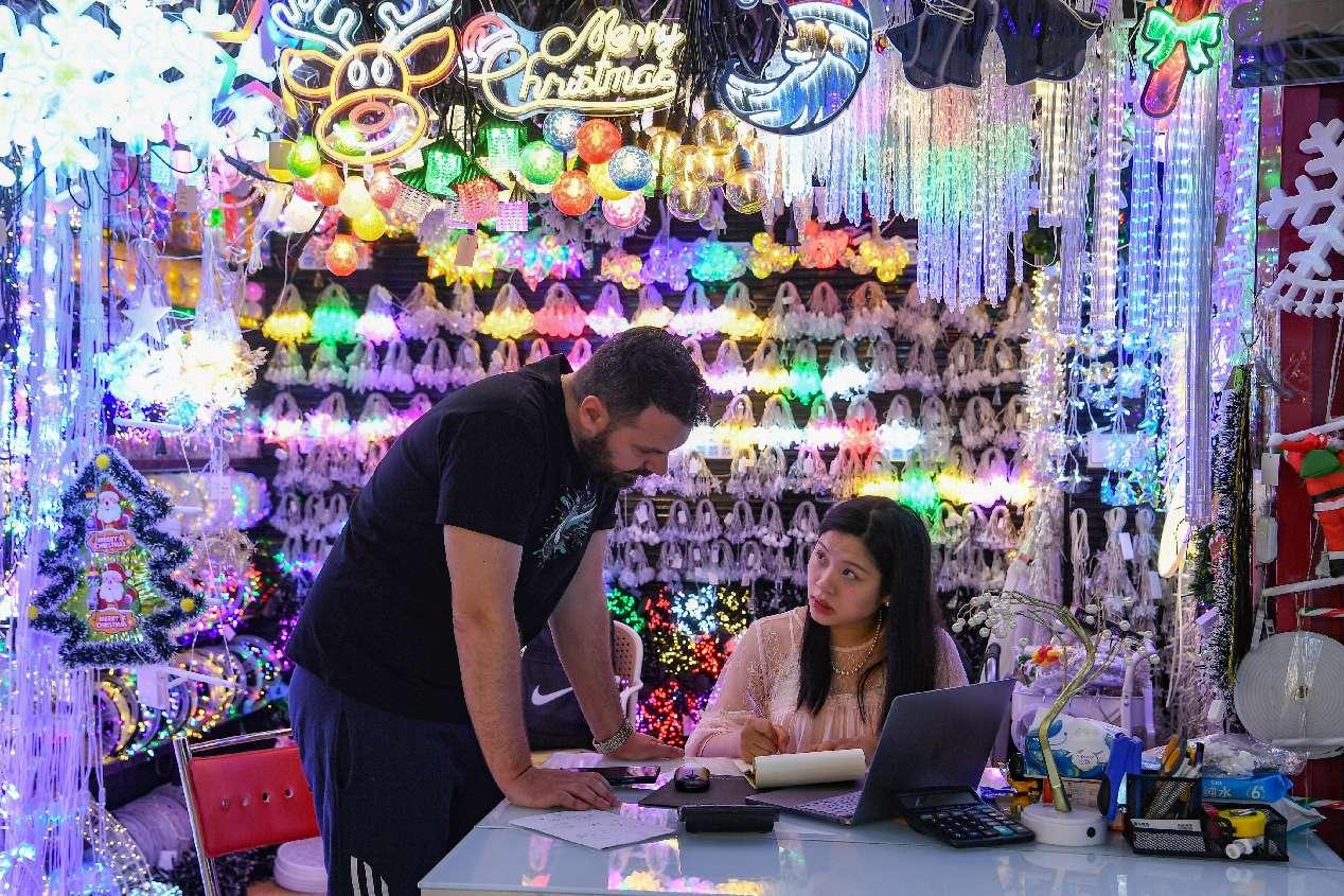 Seorang pembeli asing sedang membelek-belek barangan Hari Natal di Pasar Perdagangan Antarabangsa Yiwu, Provinsi Zhejiang di timur China, pada 13 Mei 2025. (People’s Daily Online/Shi Kuanbing)