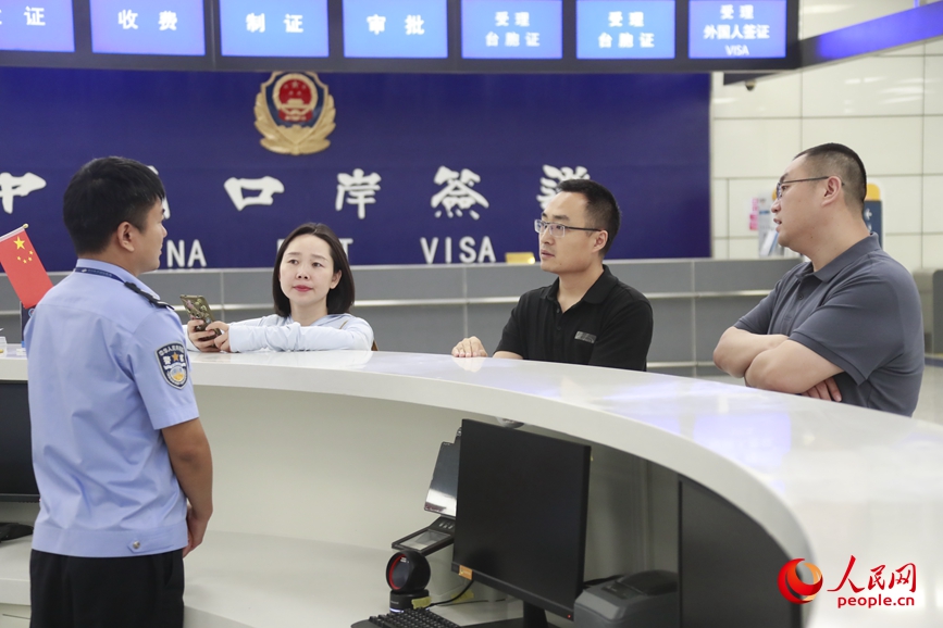 Petugas kastam berbual dengan wartawan People’s Daily Online di Lapangan Terbang Xinzheng. (People’s Daily Online/Huo Yaping)