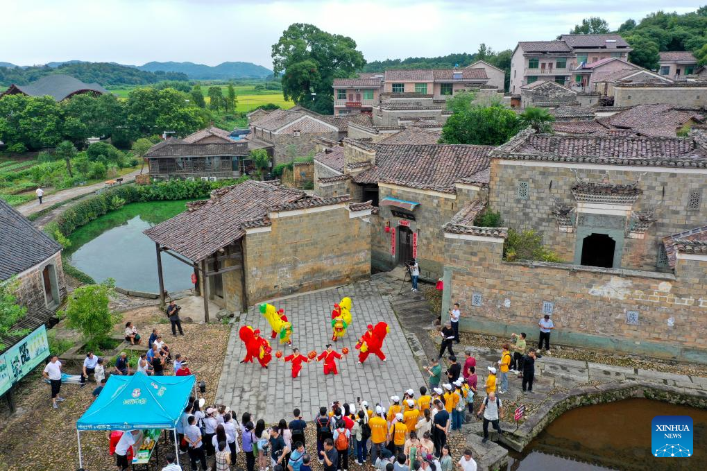 Foto dron bertarikh 9 Julai 2025 ini memaparkan sekumpulan pelancong menonton persembahan rakyat di mepemandangan Kampung Zhuqiao, kaunti Jinxi, bandar Fuzhou, provinsi Jiangxi, timur China. (Xinhua/Liu Jinhai)