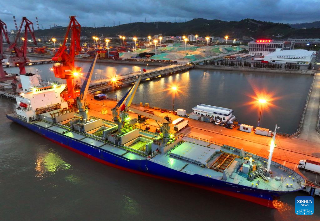 Foto udara yang diambil pada 9 Julai 2025 ini menunjukkan sebuah kapal kargo dari New Zealand menurunkan muatan di Pelabuhan Damaiyu di bandar Yuhuan, provinsi Zhejiang, timur China. (Foto oleh Duan Junli/Xinhua)