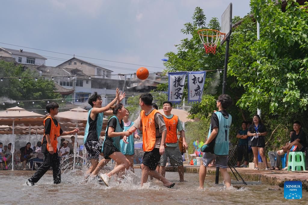 Penduduk seronok bermain bola keranjang dalam air di pekan purba Pianyan, bandar Chongqing, barat daya China, 12 Julai 2025. (Foto oleh Qin Tingfu/Xinhua)