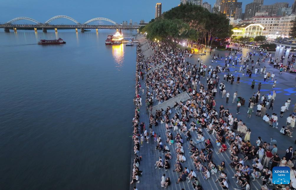 Sekeping foto sudut udara yang diambil menggunakan dron ini menunjukkan orang ramai sendang duduk di tangga untuk menikmati udara dingin di tepi Sungai Songhua, di Harbin, Provinsi Heilongjiang, timur laut China pada 25 Julai 2025. (Xinhua/Zhang Shu)