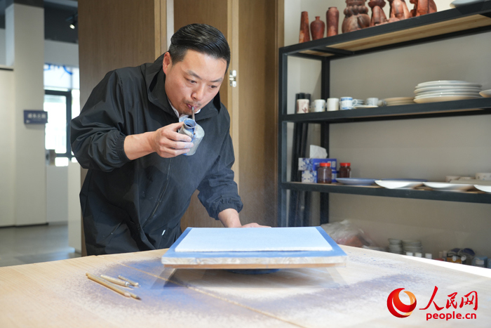Zhang Chen sedang menyiapkan kerja porselin hiasan turisan dan disadur oleh percikan biru di sebuah bengkel di Jingdezhen, Provinsi Jiangxi, di timur China. (People’s Daily Online/Kong Wenjin)