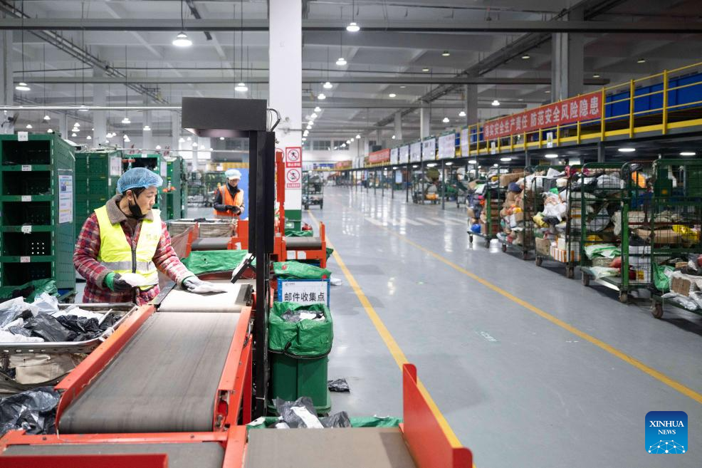 Foto ini memaparkan seorang petugas yang sedang mengisih bungkusan. (Xinhua/Zhang Tao)