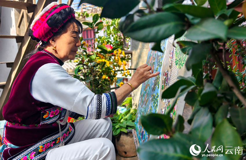 Zhao Xinlian sedang menyiapkan sebuah lukisan di Pekan Shuanglang, bandar Dali, Kawaasan Autonomi Bai Dali, di Provinsi Yunnan, barat daya China. (People’s Daily Online/Fu Hao)