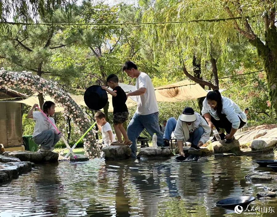 Pelancong kelihatan teruja mengayak emas di kawasan pemandangan yang dibina di tapak perlombongan terbiar di Zhaoyuan, bandar bertaraf kaunti yang ditadbir oleh Yantai, Provinsi Shandong, timur China. (People’s Daily Online/Qiao Shu)