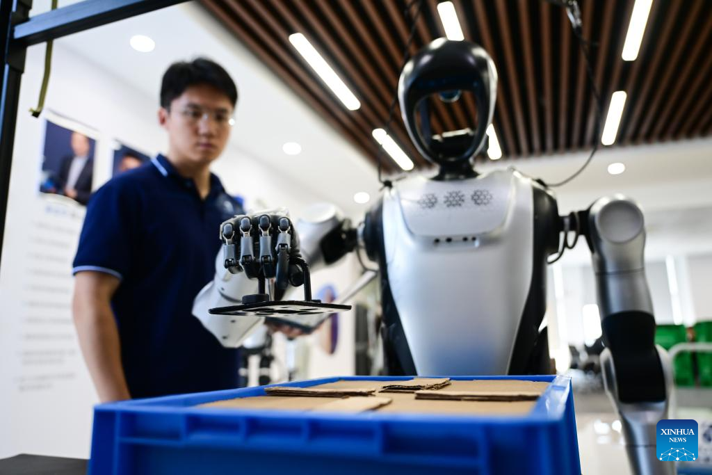 Seorang jurutera memerhatikan robot manusia mengambil komponen di makmal Leju Robotics di Hefei, provinsi Anhui, timur China, 24 Oktober 2025. (Xinhua/Zhou Mu)