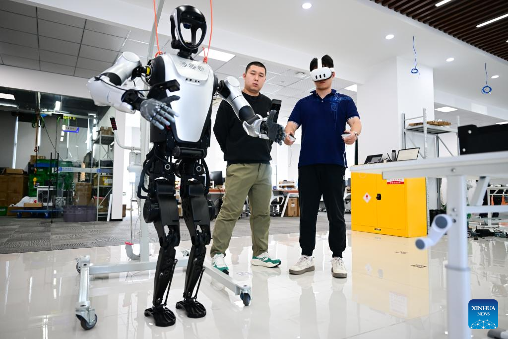 Seorang jurutera menggerakkan robot manusia menggunakan perkakasan VR untuk tujuan pengumpulan data di Leju Robotics di Hefei, provinsi Anhui, timur China, 24 Oktober 2025. (Xinhua/Zhou Mu)