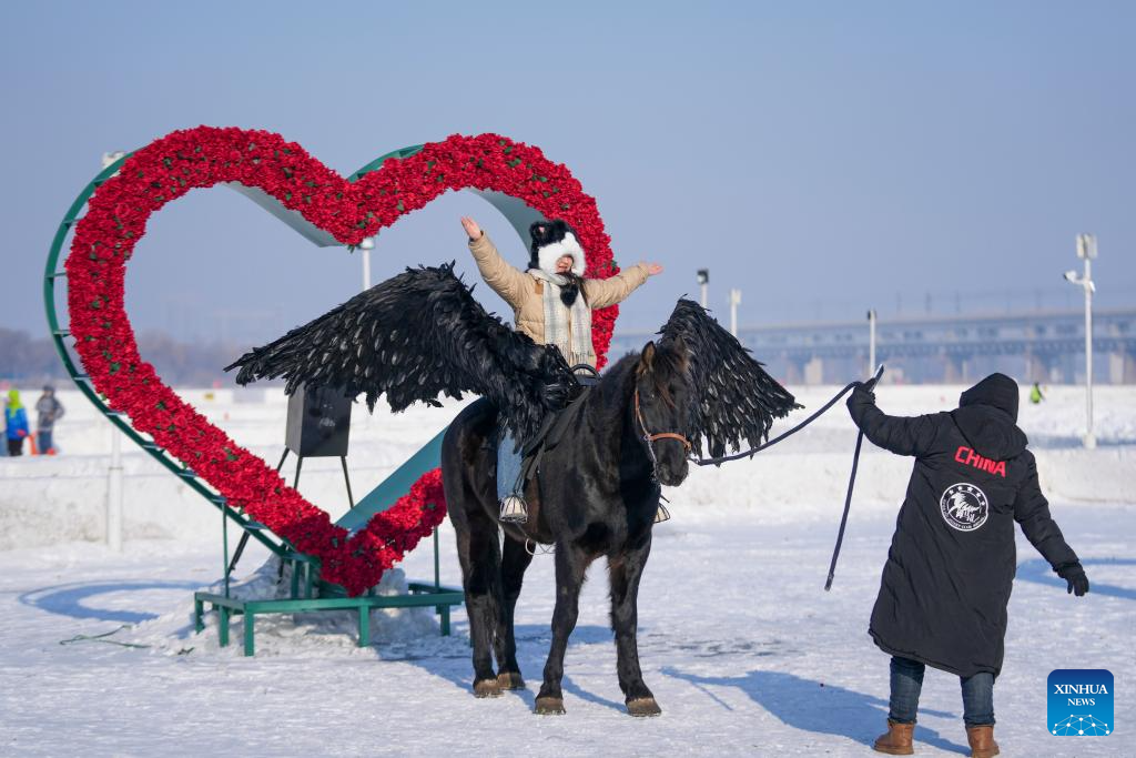 Seorang pelancong bergambar menaiki kuda di permukaan beku Sungai Songhua di Harbin, provinsi Heilongjiang, timur laut China, 11 Januari 2026. (Xinhua/Wang Jianwei)