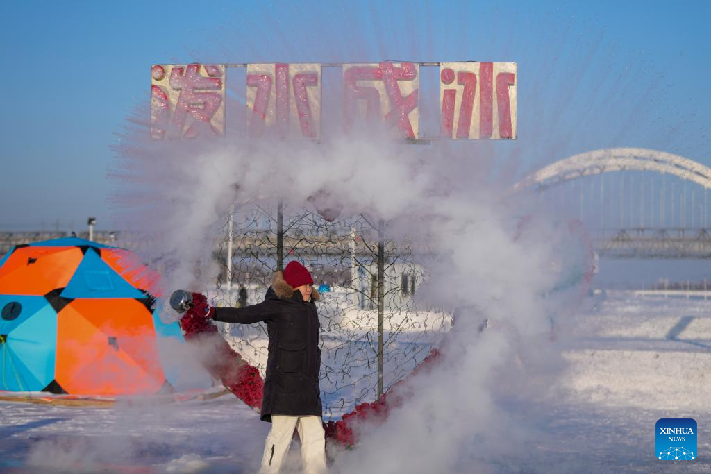 Seorang pelancong membuat aksi “air menjadi ais” dengan menyimbah air ke udara sejuk, di permukaan beku Sungai Songhua di Harbin, provinsi Heilongjiang, timur laut China, 10 Januari 2026. (Xinhua/Wang Jianwei)