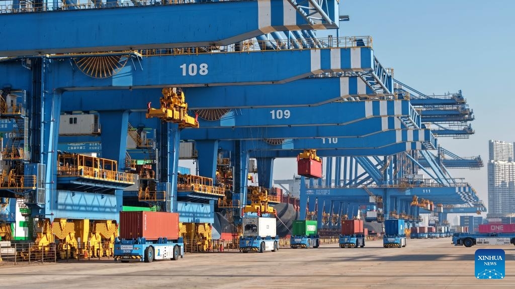 Foto dron bertarikh 4 Disember 2025 ini menunjukkan kenderaan panduan berautomasi memindahkan kontena di Terminal Kontena Qianwan Pelabuhan Qingdao, provinsi Shandong, timur China. (Xinhua/Li Ziheng)