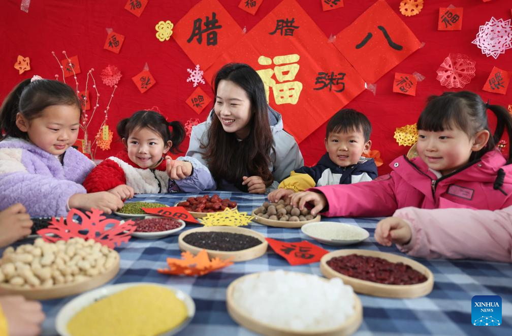 Seorang guru memperkenalkan ramuan untuk membuat bubur Laba di sebuah tadika di bandar Linyi, provinsi Shandong, timur China, 26 Januari 2026. (Wang Yanbing/Xinhua)