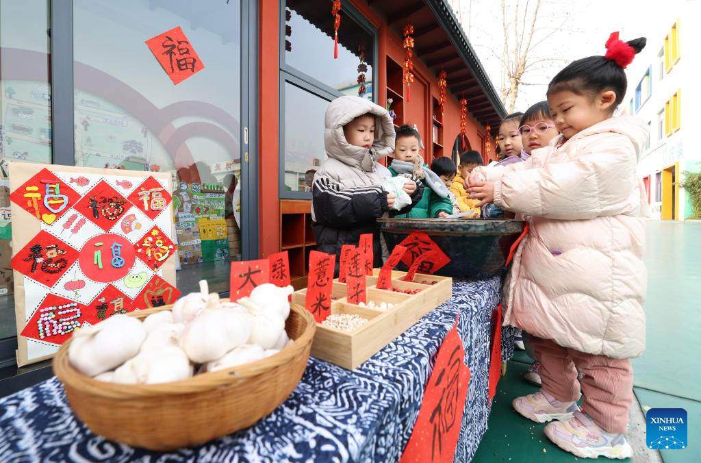 Kanak-kanak menyediakan ramuan untuk membuat bubur Laba di sebuah tadika di kaunti Zhengding, Shijiazhuang, provinsi Hebei, utara China, 26 Januari 2026. (Liang Zidong/Xinhua)