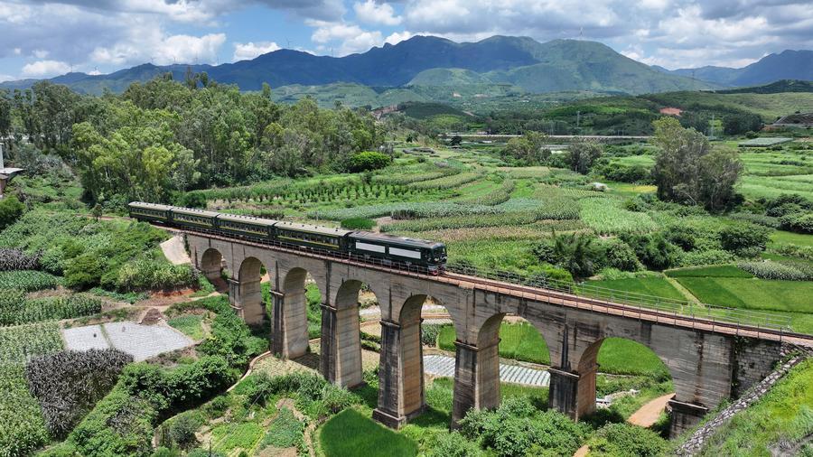 Foto udara yang diambil pada 3 Ogos 2025 ini menunjukkan sebuah kereta api persiaran di jambatan tujuh lengkung Rel Yunnan-Vietnam di bandar Kaiyuan, provinsi Yunnan, barat daya China. (Li Yunsheng/Xinhua)