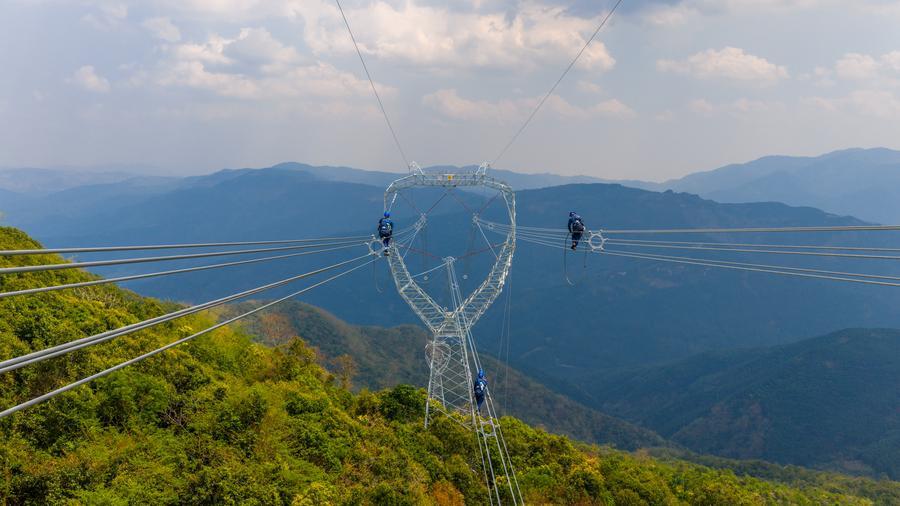 Foto dron menunjukkan juruteknik sedang memeriksa satu seksyen talian penghantaran kuasa dalam projek ketersambungan 500-kV China-Laos di kawasan autonomi Dai Xishuangbanna, provinsi Yunnan, barat daya China, 14 April 2026. (Xinhua)