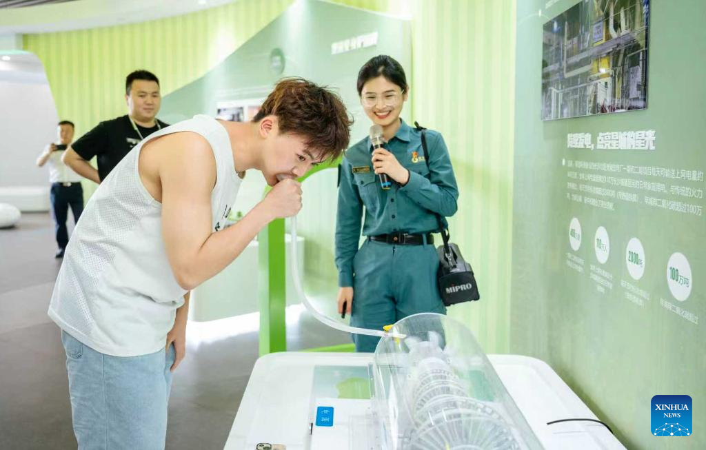 Foto fail menunjukkan seorang pengunjung sedang belajar tentang proses penjanaan kuasa melalui pembakaran sisa menerusi sebuah peranti di taman perlindungan alam sekitar Heimifeng di bandar Changsha, provinsi Hunan, tengah China. (Xinhua)