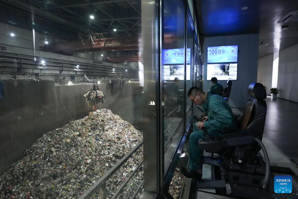 Kakitangan mengendalikan lengan mekanikal untuk mengangkut sisa ke alat pembakar di taman perlindungan alam sekitar Heimifeng di bandar Changsha, provinsi Hunan, tengah China, 22 April 2026. (Xinhua/Chen Zhenhai)