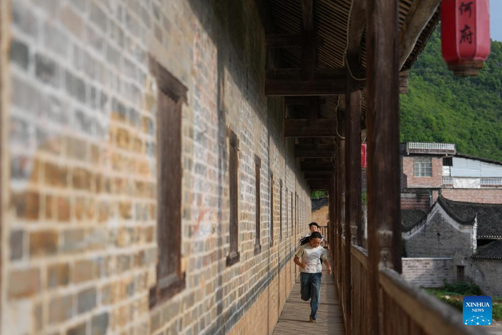 Kanak-kanak main kejar-kejar di sebuah kediaman purba Zouma Diaolou, juga dipanggil Changgong Lou, di kampung Baojing di Yongzhou, provinsi Hunan, tengah China, 9 Mei 2026. Chen Zhenhai)