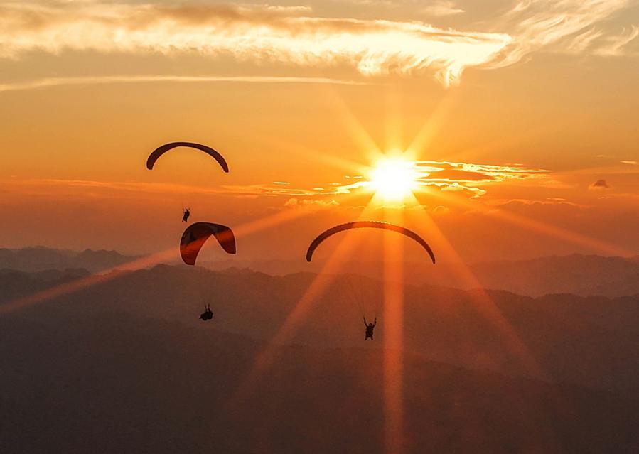 Foto dron bertarikh 30 Julai 2026 ini menunjukkan pelancong meluncur layar bersama peluncur profesional di sebuah pangkalan di pekan Jiuzhou, kaunti Huangping, provinsi Guizhou, barat daya China. (Xinhua/Yang Wenbin)