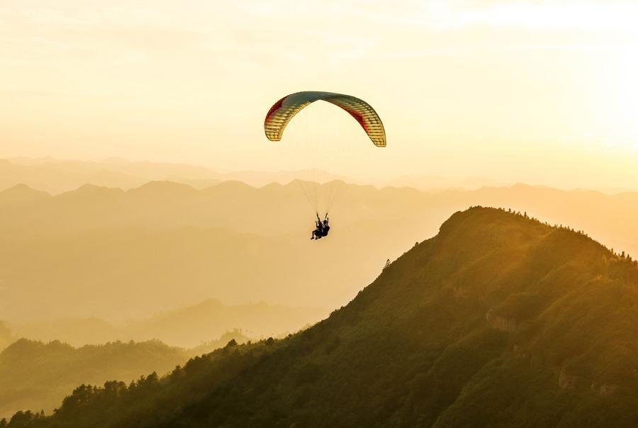 Foto dron bertarikh 30 Julai 2026 ini menunjukkan pelancong meluncur layar bersama peluncur profesional di sebuah pangkalan di pekan Jiuzhou, kaunti Huangping, provinsi Guizhou, barat daya China. (Xinhua/Yang Wenbin)