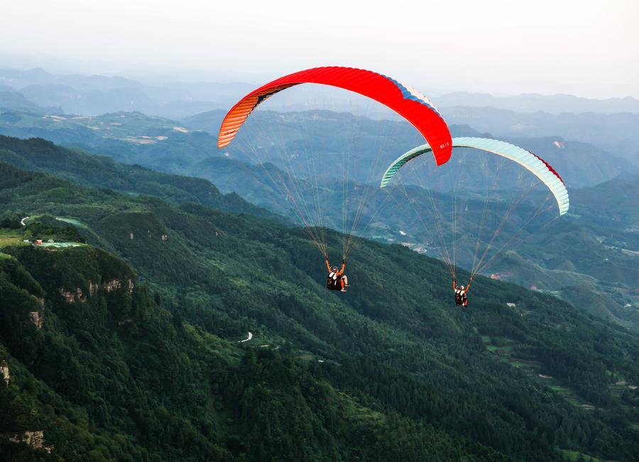Foto dron bertarikh 30 Julai 2026 ini menunjukkan pelancong meluncur layar bersama peluncur profesional di sebuah pangkalan di pekan Jiuzhou, kaunti Huangping, provinsi Guizhou, barat daya China. (Xinhua/Yang Wenbin)